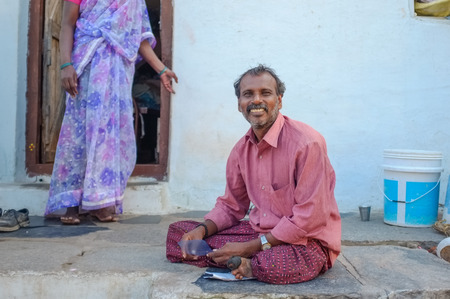 KAMALAPURAM, INDIA - 02 FABRUARY 2015: Indian man sitting infront of house in a town close to Hampiのeditorial素材