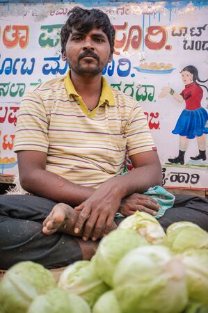 KAMALAPURAM, INDIA - 02 FABRUARY 2015: Indian middle-aged man selling vegetables on a market close to Hampiのeditorial素材