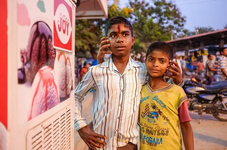 KAMALAPURAM, INDIA - 02 FABRUARY 2015: Two Indian brothers hugging in street and fooling around with people around themのeditorial素材