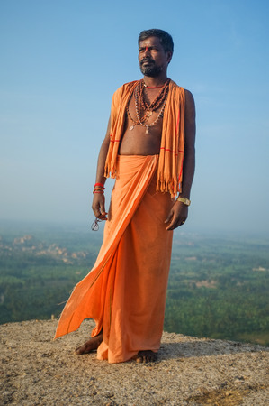 KAMALAPURAM, INDIA - 03 FEBRUARY: Indian pilgrim with religious necklaces and scarf in lungi on...