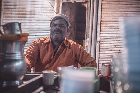 JODHPUR, INDIA - 11 FEBRUARY 2015: Indian man selling milk tea sits in-front of shop. Post-processed...