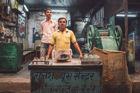 JODHPUR, INDIA - 17 FEBRUARY 2015: Vendor makes sugarcane juice in specialised machine. Finished juice is stored and covered with cotton rag. Post-processed with grain and texture.のeditorial素材