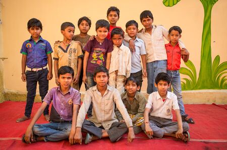 GODWAR REGION, INDIA - 15 FEBRUARY 2015: Boys pose for a group photo in front of wall on red carpet during preparation of wedding.のeditorial素材