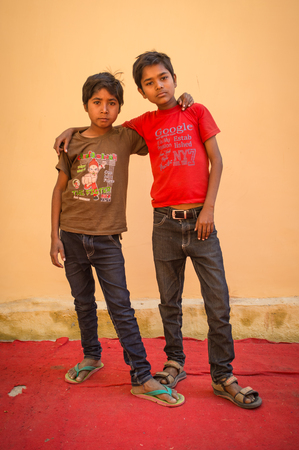 GODWAR REGION, INDIA - 15 FEBRUARY 2015: Two Indian boys hug in front of blank wall on red carpet during wedding celebrations.のeditorial素材