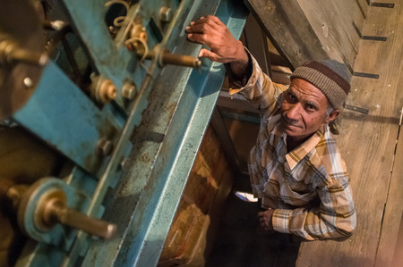 JODHPUR, INDIA - 11 FEBRUARY 2015: Ghanta Ghar clock man stands next to clock mechanism inside...