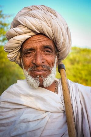GODWAR REGION, INDIA - 14 FEBRUARY 2015: Elderly Rabari tribesman with white turban and blanket around the shoulders and axe. Rabari or Rewari are an Indian community in the state of Gujarat.のeditorial素材