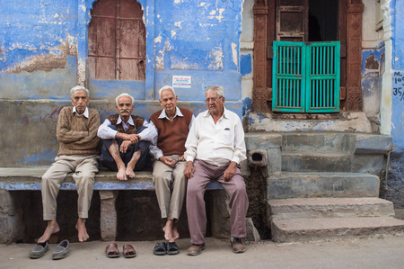 JODHPUR, INDIA - 16 FEBRUARY 2015: Four elderly men sit on stone bench on street infront of house.のeditorial素材