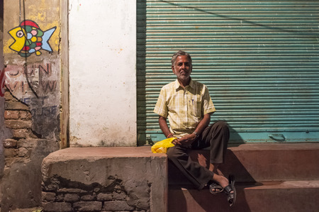 VARANASI, INDIA - 19 FEBRUARY 2015: Indian man sits infront of closed store.のeditorial素材
