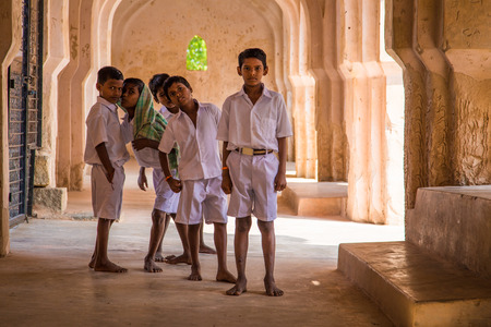 HAMPI, INDIA - 30 JANUARY 2015: Five schoolboys stand inside Queens's bath ruins. It is a colossal bath that exemplifies the architectural excellence prevalent during the days of the Vijayanagara Empire.のeditorial素材