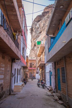 JODHPUR, INDIA - 09 FEBRUARY 2015: Street in old town with parked motorbikes under fort on rocky hill.のeditorial素材