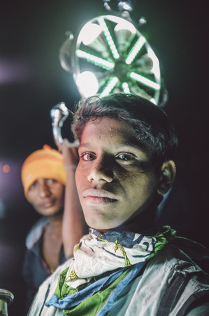 JODHPUR, INDIA - 08 FEBRUARY 2015: Young Indian boys work as light holders in bride-grooms wedding procession. Post-processed with grain, texture and colour effect.のeditorial素材