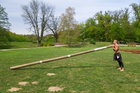 Young athlete man climbing the rope tied to metal construction as part of crossfit training.の写真素材