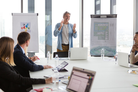 Business man clapping hands after successful meeting  in modern office.