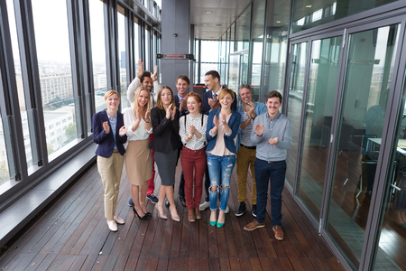 Group shot of business people in modern office hall.