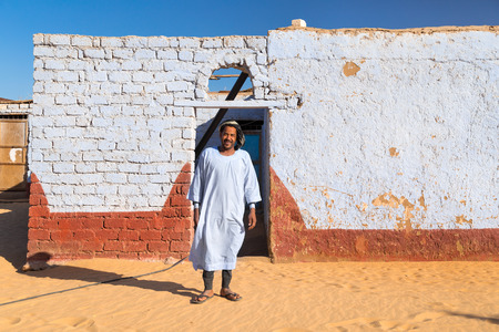 ASWAN, EGYPT - FEBRUARY 7, 2016: Nubian man wearing traditional clothing standing in front of the house.のeditorial素材
