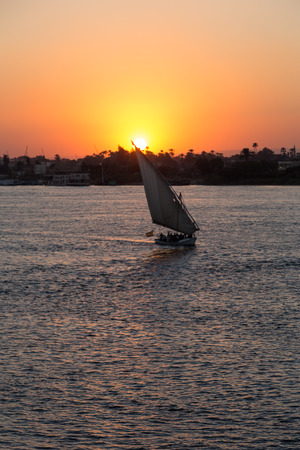 Tourist sailboat at Luxor waterfront during sunset.の写真素材