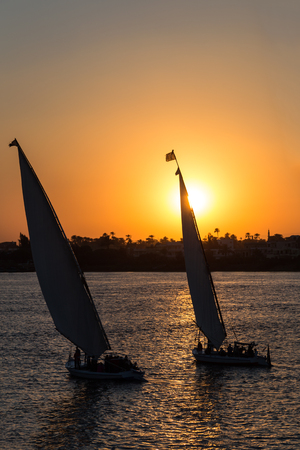 Tourist sailboats at Luxor waterfront during sunset.の写真素材