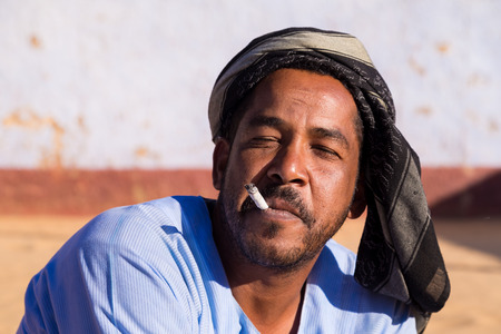 ASWAN, EGYPT - FEBRUARY 7, 2016: Portrait of Nubian man smoking cigarette.のeditorial素材