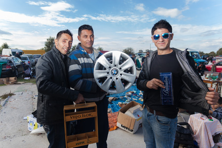 ZAGREB, CROATIA - OCTOBER 20, 2013: Roma salesmen holding used car rim and whiskey package at...