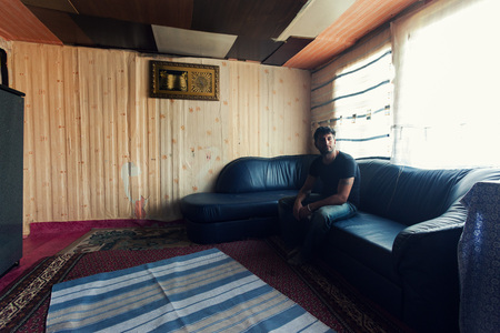 ZAGREB, CROATIA - OCTOBER 21, 2013: Roma man sitting on a couch in his home.のeditorial素材
