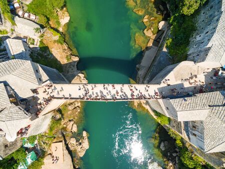 Aerial view of people crossing Old Bridge over Neretva river in Mostar, Bosnia and Herzegovina.のeditorial素材