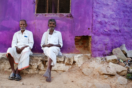 KAMALAPURAM, INDIA - 02 FEBRUARY 2015: Local Indian men resting and socialising on the street in front of a purple coloured home.のeditorial素材