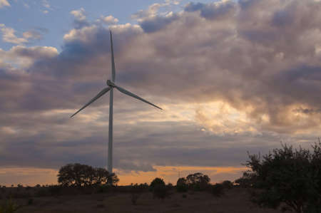 windmill on a hill at sunset with clouds