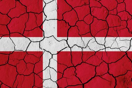 Flag of Denmark over cracked background, conceptual image of crisis