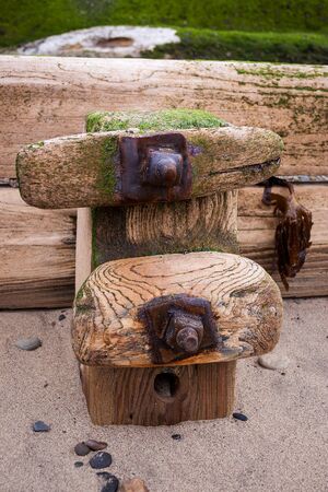 The waves sweep out and etch their movements on the resilient groynes which stand on the beach at Sandsendの写真素材