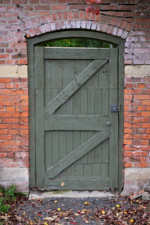 Wooden garden dorr in a red brick wallの写真素材