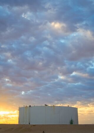 Oil Storage Tank - Early morning sun at a desert locationの写真素材