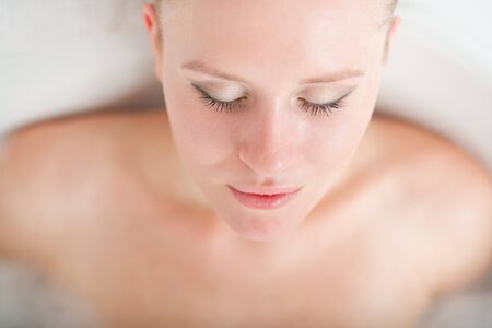 Bath woman enjoying bathub  Naturally beautiful female relaxing in bath with foam in bathroom