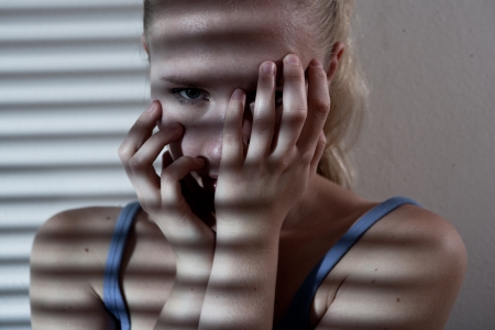 Portrait of a unhappy and depressed young woman in depressive stripe environment, desaturated imageの写真素材