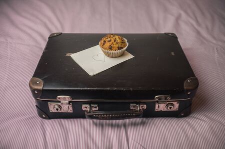 packed vintage suitcase with a surprise- muffin and a love letter noteの写真素材