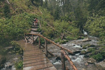 hiker walking through wilderness  in heavy rain wearing rainshell jacketの写真素材