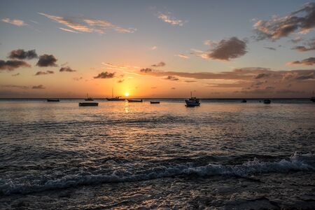 sunset at the coast in the caribbean with fishing boats in backgroundの写真素材