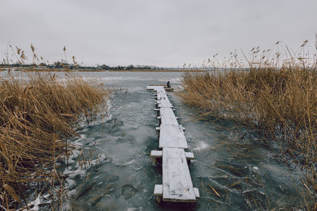 Wooden jetty on a frozen lake on a winter dayの写真素材