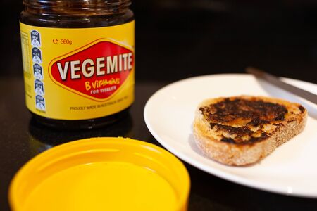 Sydney, Australia - November 2, 2019 - Vegemite and butter on sough dough toast, knife and Vegemite jar. An classic icon Australian spread.のeditorial素材