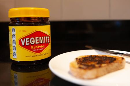 Sydney, Australia - November 2, 2019 - Vegemite and butter on sough dough toast, knife and Vegemite jar. An classic icon Australian spread.のeditorial素材