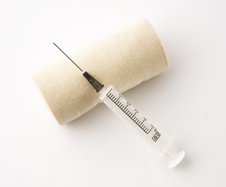 Medical syringe and bandage isolated on a white backgroundの写真素材