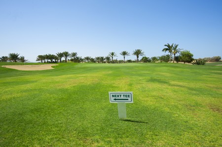 Sign on the fairway of a golf course indicating way to next holeの写真素材