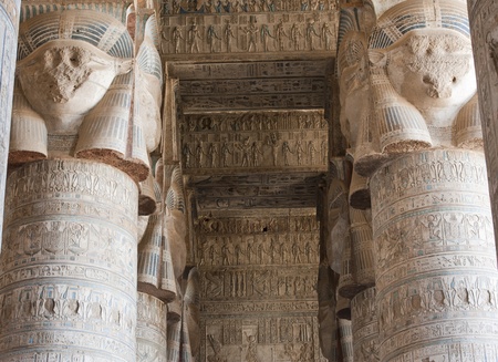Columns inside an ancient egyptian temple covered in hieroglyphic carvings and paintingsのeditorial素材