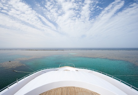 View from the bow of a large private motor yacht on tropical sea with cloudy skyの写真素材