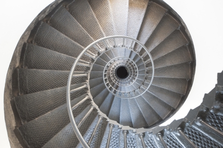 View down a spiral staircase in a lighthouse seemingly going to infinityの写真素材