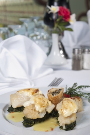 Main meal of fish and spinach a la carte in a restaurantの写真素材