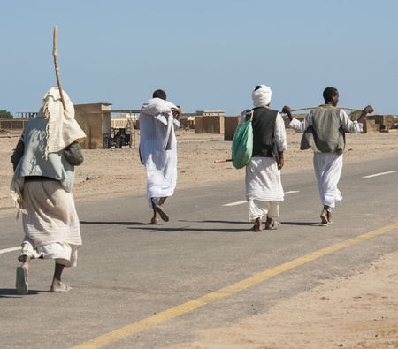 Four traditional egyptian bedouins walking down a road in a remote rural townのeditorial素材