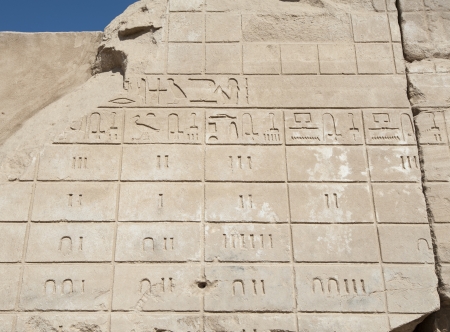 Ancient Egyptian hieroglyphic carvings on a temple wall at Karnak in Luxor