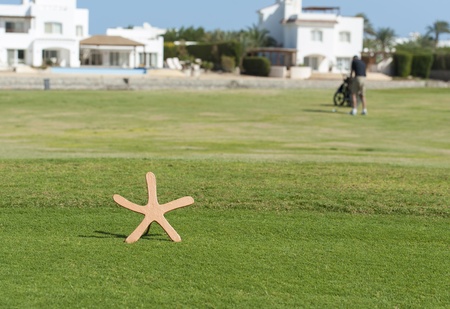 Star shaped tee marker on a golf course with golfer in the distance on fairwayのeditorial素材