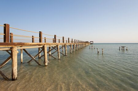 Long wooden jetty on a tropical island stretching out into the seaの写真素材