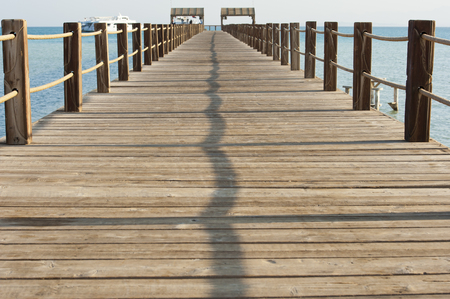 Long wooden jetty on a tropical island stretching out into the seaの写真素材